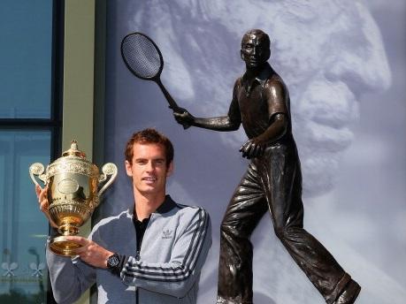 Sunnier times...Andy Murray with his Wimbledon trophy by the Fred Perry statue